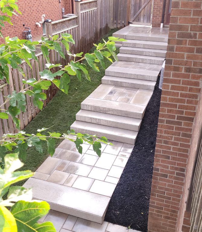 A walkway with steps leading to the side of a house.