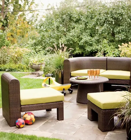 A patio with furniture and a table in the middle of it.