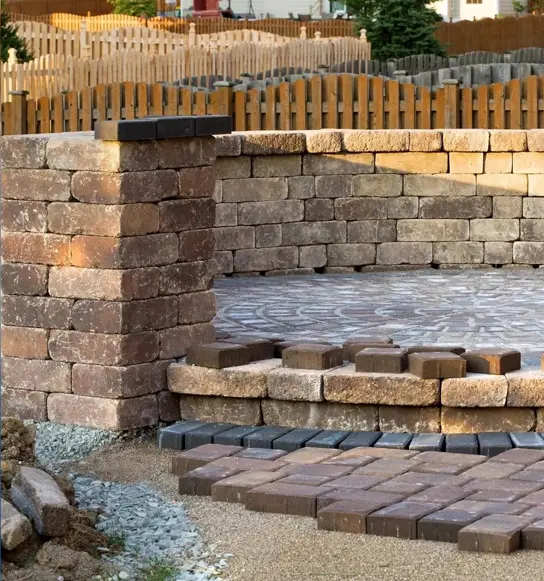 A brick wall with steps and rocks in the middle.