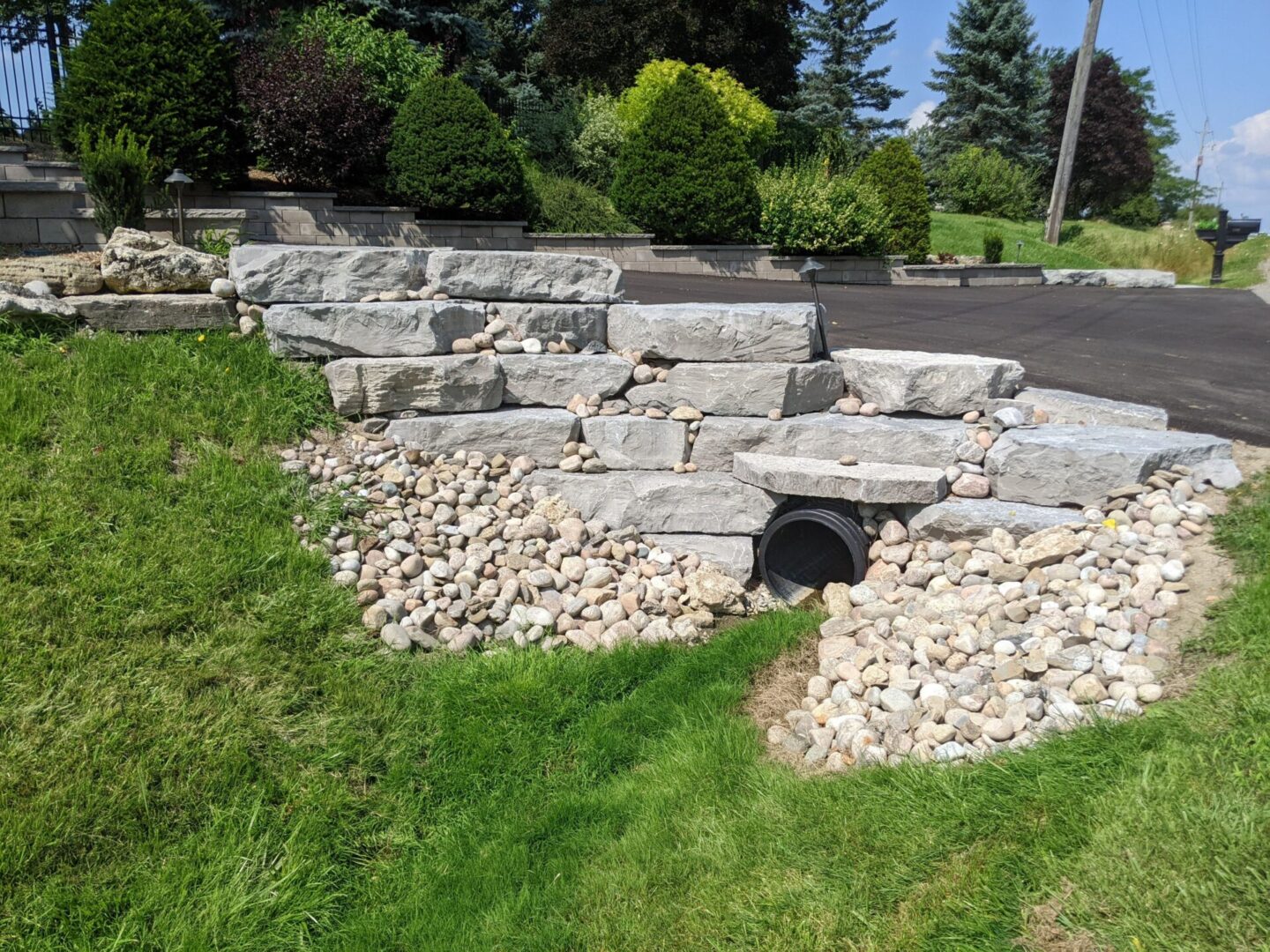 A stone wall with grass growing around it.