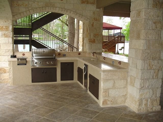 A large outdoor kitchen with an oven and grill.